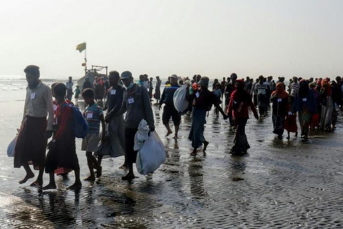 The 17 men, women and children looking exhausted from their ordeal as they climbed down from a wooden boat on to a beach near western Rakhine state's capital, Sittwe