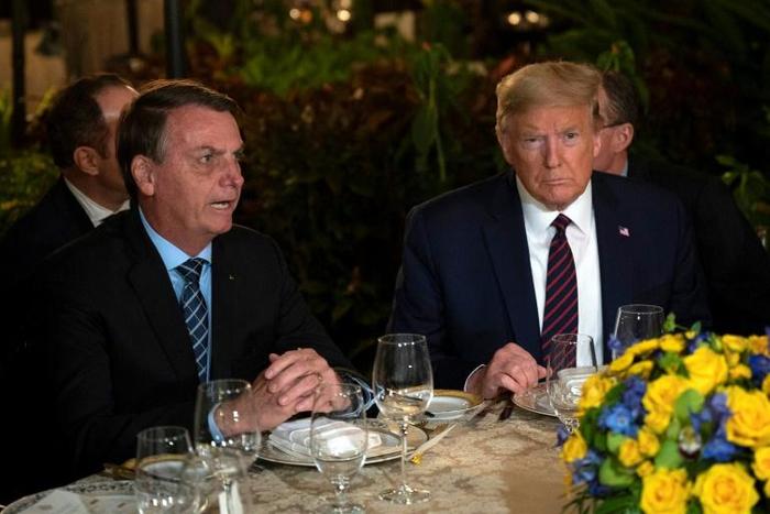 (FILES) In this file photo US President Donald Trump (R) speaks with Brazilian President Jair Bolsonaro during a dinner at Mar-a-Lago in Palm Beach, Florida, on March 7, 2020