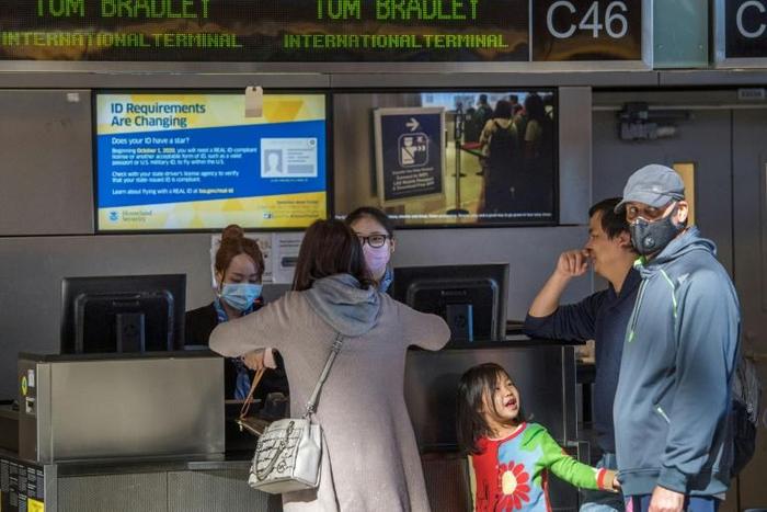 Stand-by passengers trying to get out of China make flight enquiries at the airport