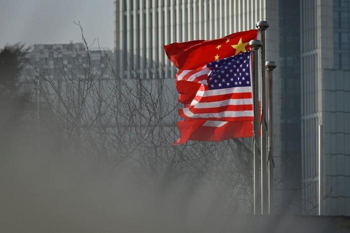 Chinese and US flags flutter outside a corporate building in Beijing in January 2020