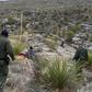 Border patrol agents Arain Carrera and Thaddeus Cleveland approach an injured Guatemalan migrant in a remote canyon of west Texas