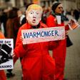 A protester holds up a placard, dressed as US President Donald Trump in Trafalgar Square during a demonstration against the threat of war on Iran, in central London on January 11, 2020