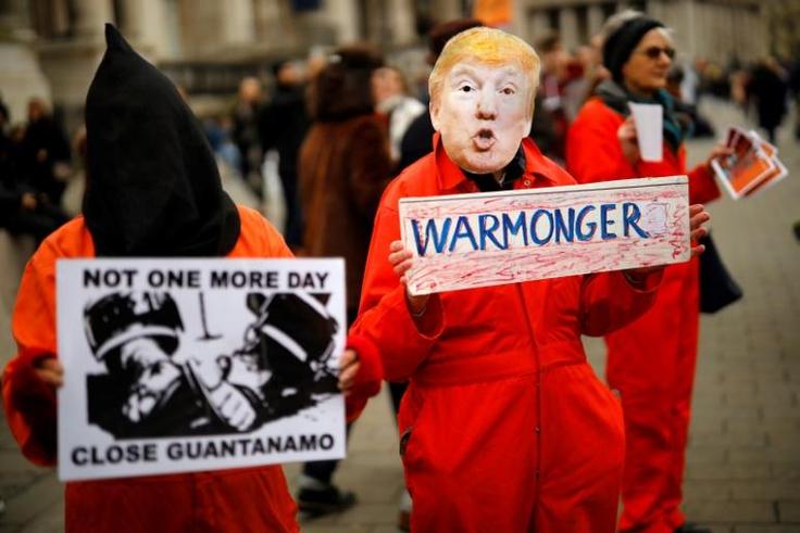 A protester holds up a placard, dressed as US President Donald Trump in Trafalgar Square during a demonstration against the threat of war on Iran, in central London on January 11, 2020
