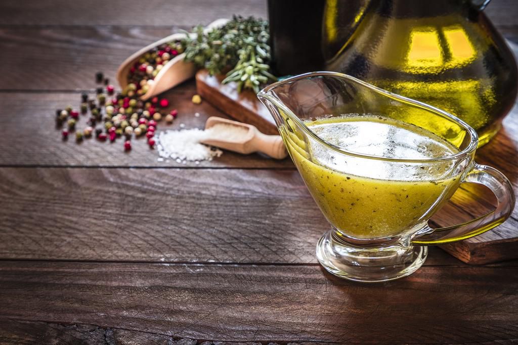 Vinaigrette dressing with copy space on a rustic wooden table
