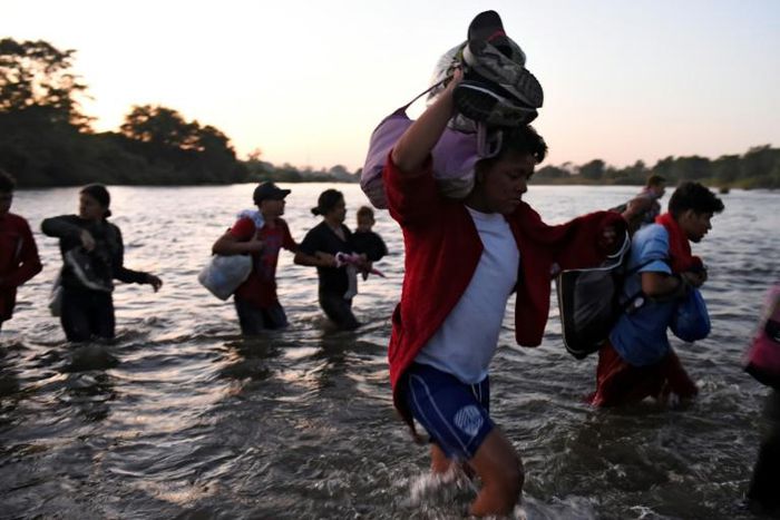 Central American migrants -- mostly Hondurans heading to the US in a caravan -- cross the Suchiate River from Tecun Uman, Guatemala, to Ciudad Hidalgo, Chiapas State, Mexico, on January 23, 2020