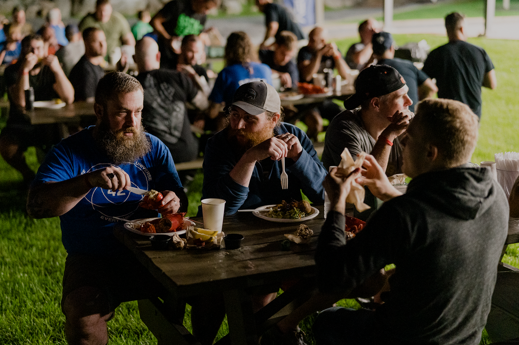 Mooney (second left) refuels at the camp lobster bake.
