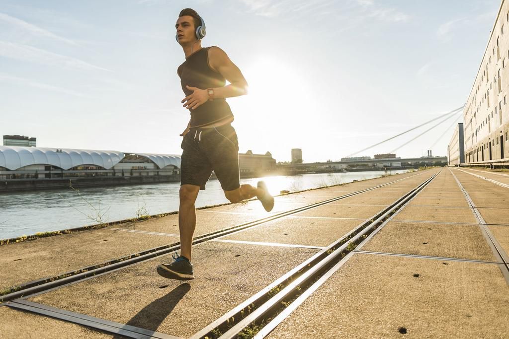 Young athlete jogging in the city at the river