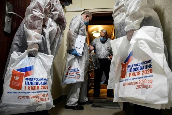 A voter casts a ballot into a mobile ballot box in Moscow during the early vote in a nationwide constitutional referendum that could extend President Vladimir Putin's term