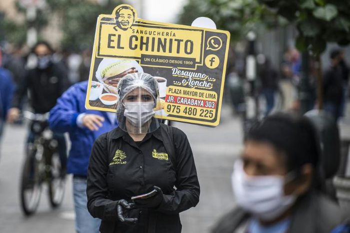 A woman promotes a sandwich restaurant in downtown Lima mandatory national quarantine due to the COVID-19 coronavirus pandemic