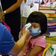 A young pupil has her temperature checked on the first day schools resumed in Singapore following the easing of some coronavirus restrictions