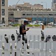 A masked man checks his phone in Qatar where residents and citizens have been required by law to install a coronavirus contact tracing app on their handsets since Friday