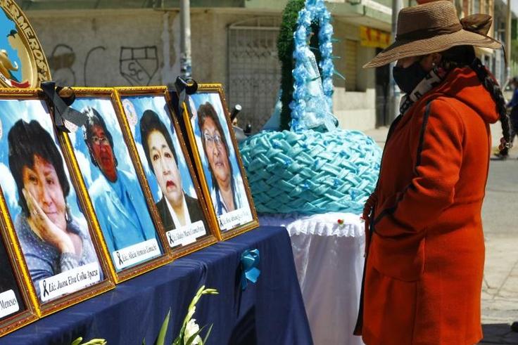 A woman looks at photos of health workers in Puno, Peru who died from Covid-19