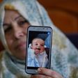 The grandmother of Palestinian baby Omar Yagi displays a picture of him taken before his death in Gaza last week from a serious heart condition he had been due to receive life-saving surgery in Israel for