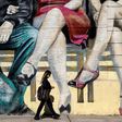 A woman walks past a mural featuring tango dancers in Buenos Aires