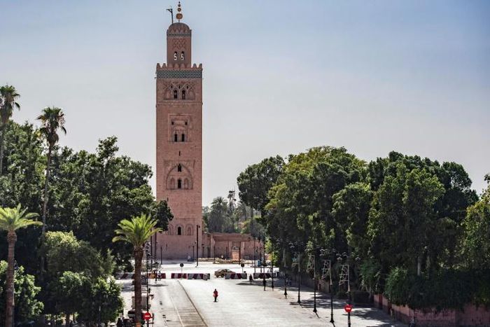 A few people walk by next to the Kutubiyya mosque's minaret tower at the Jemaa el-Fna square in the Moroccan city of Marrakesh on September 8, 2020, currently empty of its usual crowds due to the COVID-19 pandemic
