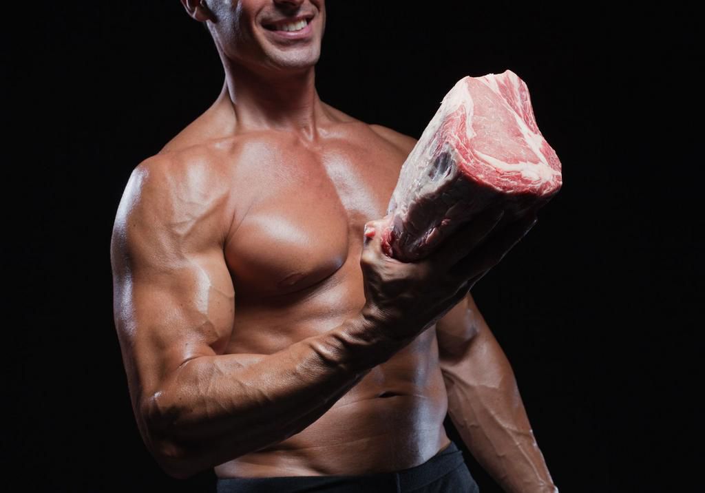 Bodybuilder holding meat