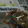 A paramilitary soldier gestures while standing guard outside the Pakistan Stock Exchange  after gunmen attacked the building