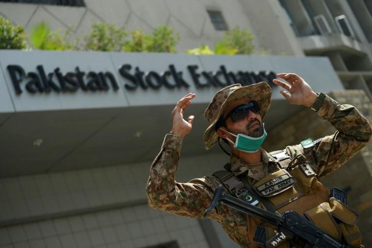 A paramilitary soldier gestures while standing guard outside the Pakistan Stock Exchange  after gunmen attacked the building