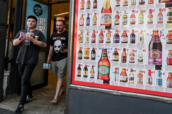 Two men leave a so-called "bottle shop" in Melbourne after major alcohol retailers in Australia agreed to enforce new rules limiting individual purchases