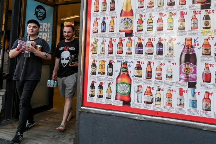Two men leave a so-called "bottle shop" in Melbourne after major alcohol retailers in Australia agreed to enforce new rules limiting individual purchases