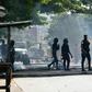 Police clear debris that was placed in the road by young demonstrators during protests against President Alassane Ouattara's run for a third term, in the Yopougon neighbourhood of Abidjan on August 13, 2020