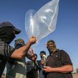 Palestinian militants attach a fire bomb to inflated plastic bags and condoms before launching it across the Gaza border into Israel