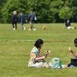 Two women enjoy a drink in the grass in London's Hyde Park, opened for the first time in months