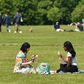 Two women enjoy a drink in the grass in London's Hyde Park, opened for the first time in months