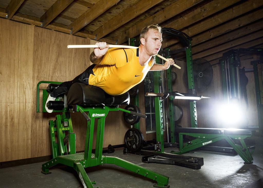 Pete Alonso in back extension setup, glutes tight, maintaining straight torso position.