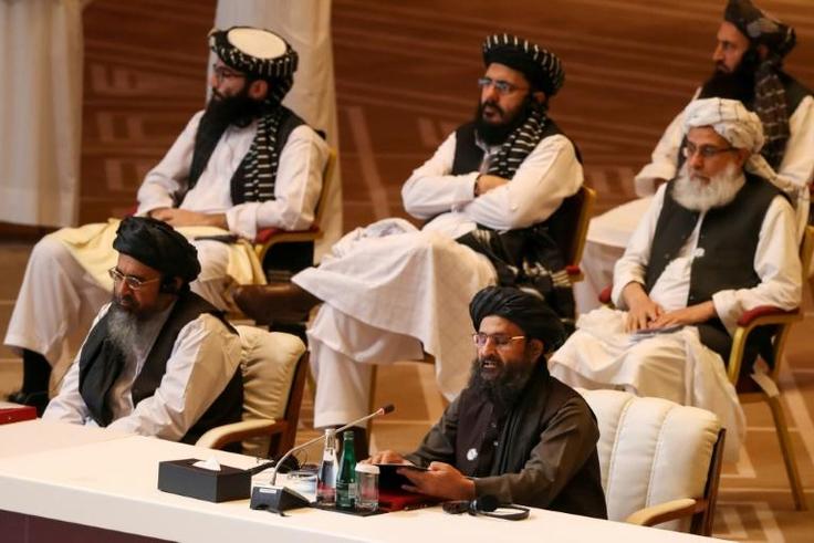 Taliban co-founder Mullah Abdul Ghani Baradar (R, bottom) speaks during the opening session of peace talks with the Afghan government