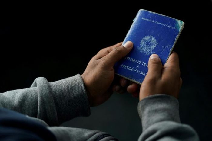 A man holds his work document at a job fair in 2019 in Rio de Janeiro, Brazil -- the country's unemployment rate has now risen to to 13.3%