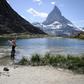 A tourist poses for a picture in the Riffelsee mountain lake with the Matterhorn mountain in background above the resort of Zermatt as heatwave sweeps across Europe