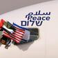 The Emirati, US and Israeli flags fly from the cockpit window of an Israeli El Al aircraft below the word "peace" in Arabic, English and Hebrew, upon its arrival at the Abu Dhabi airport Monday