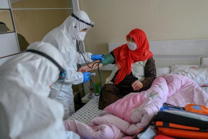 Health workers help a woman who tested positive for the novel coronavirus COVID-19,  at Bagcilar in Istanbul