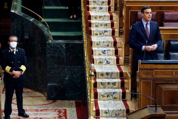 Spanish Prime Minister Pedro Sanchez speaks from his seat during a session to debate the extension of a national lockdown to curb the spread of the novel coronavirus at the Lower Chamber of the Spanish parliament in Madrid