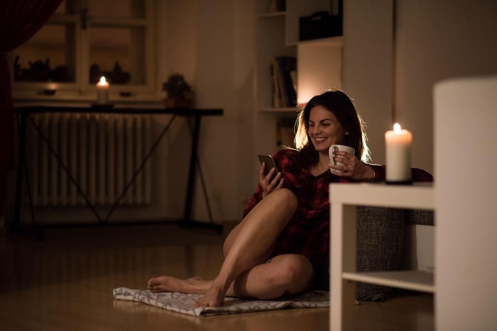Cheerful relaxed woman in her apartment having coffee