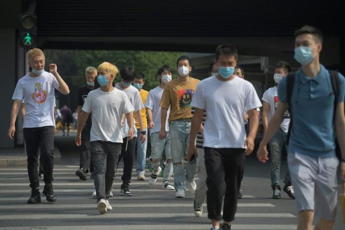 Pedestrians wear face masks in Beijing, China. Authorities in the country had appeared to have the virus largely under control
