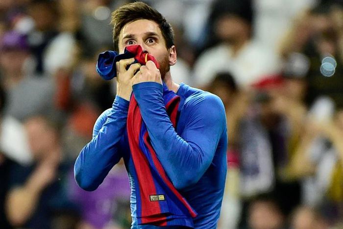 Barcelona forward Lionel Messi kisses his jersey after brandishing it to celebrate his goal against Real Madrid