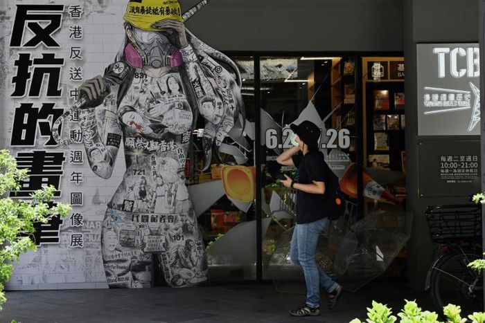 A woman in Taipei walks past a billboard promoting democracy for Hong Kong
