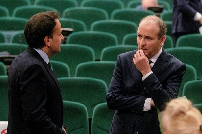 Fianna Fail leader Micheal Martin (R) talks with the man who he has replaced as Irish prime minister, Leo Varadkar after the vote at a special sitting of the Dail parliament