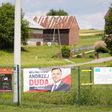 A campaign poster bearing a portrait of President Duda is displayed on a fence in Godziszow, a bedrock of his conservative administration