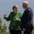 German Chancellor Angela Merkel confers with US President Donald Trump following a family photo session during the G7 Summit in La Malbaie, Canada in 2018