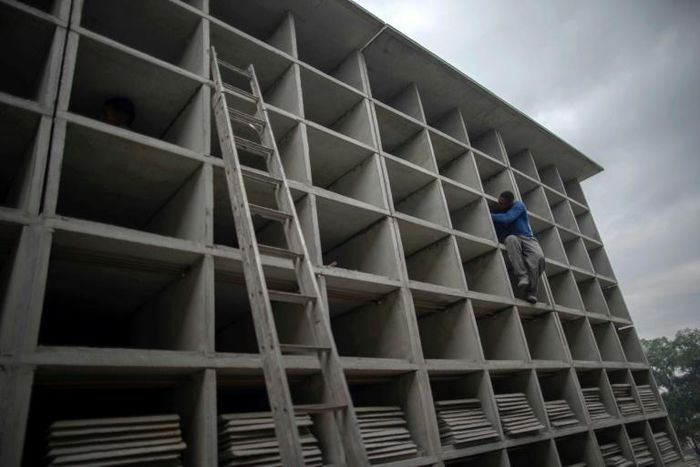 A worker builds vertical graves during the COVID-19 coronavirus pandemic at the Caju Cemetery in Rio de Janeiro, Brazil