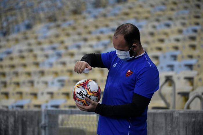 A ball boy disinfects the ball during a Carioca Championship 2020 football match between Flamengo and Bangu at the Maracana stadium, in Rio de Janeiro, Brazil, on June 18, 2020