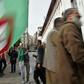 An Algerian protester waves the national flag during a weekly anti-government demonstration in the capital Algiers on March 13 before the rallies were suspended because of the novel coronavirus