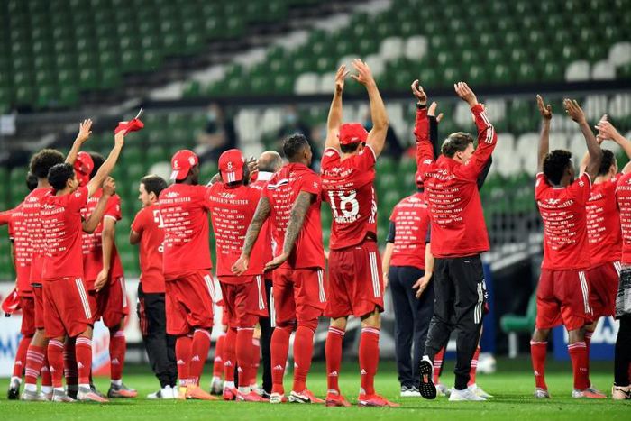 Bayern Munich players celebrate in front of near-empty stands after securing an eighth straight Bundesliga title