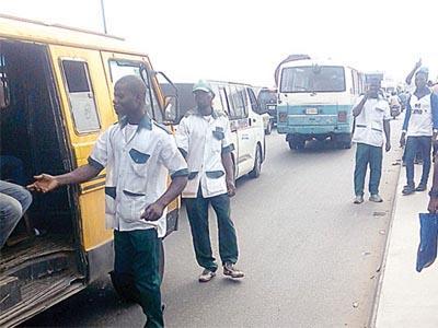 Transport union members at a Lagos bus stop following the state's announcement of a sanitation monitoring initiative.