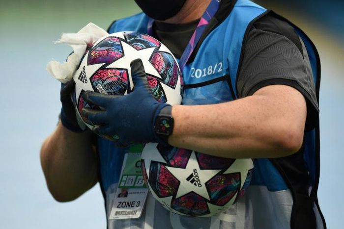 A member of the ground staff disinfects a ball before the Champions League last 16 match between Manchester City and Real Madrid at the Etihad Stadium in Manchester on August 7