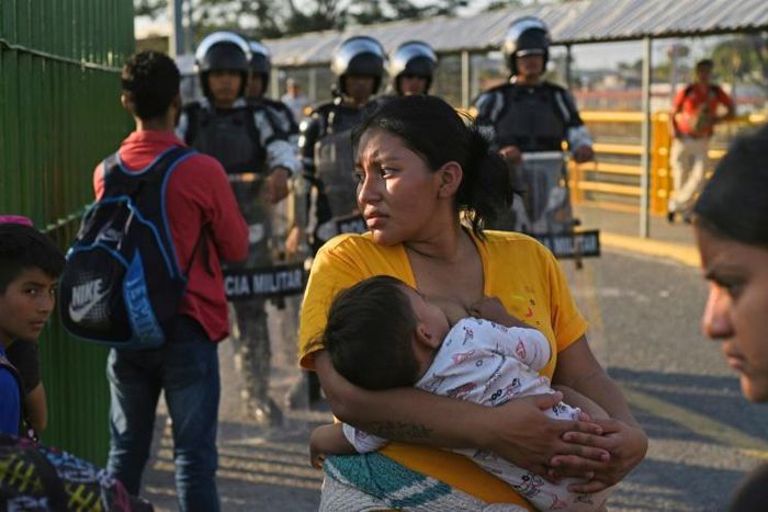 Honduran migrants wait to cross the international border bridge from Ciudad Tecun Uman in Guatemala to Ciudad Hidalgo in Mexico in January 2020