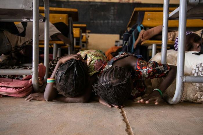 Children hide on the ground during a drill for potential attacks in Burkina Faso, where such assaults have shuttered 3,500 schools